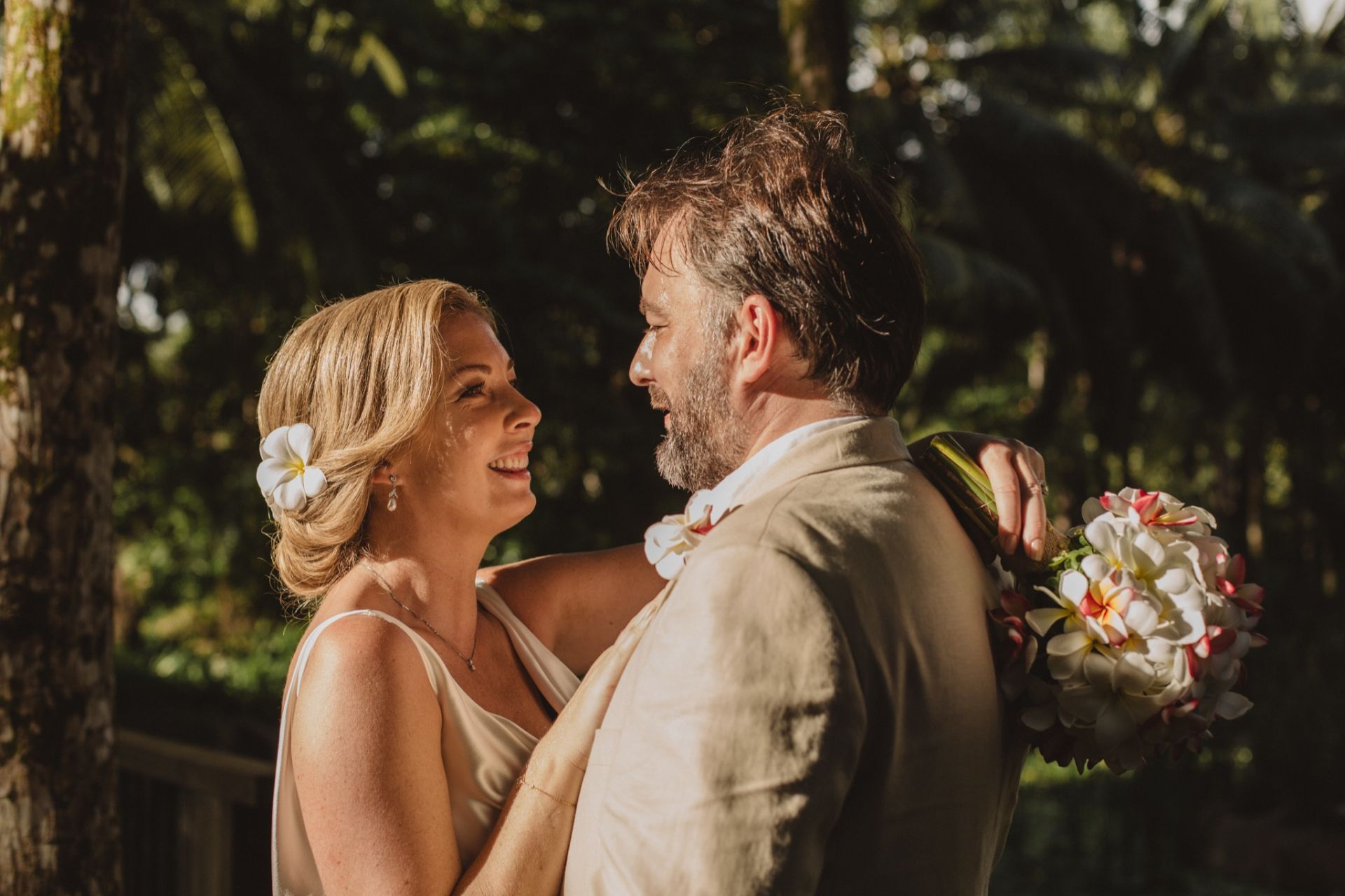 Couple marrying barefoot on a Seychelles beach at golden hour